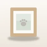 Natural wood pet memorial photo frame holding a soft paw print artwork on a warm ivory surface