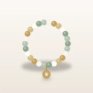 Beaded pet remembrance bracelet in sage and ivory tones with a small engraved charm on a warm ivory surface